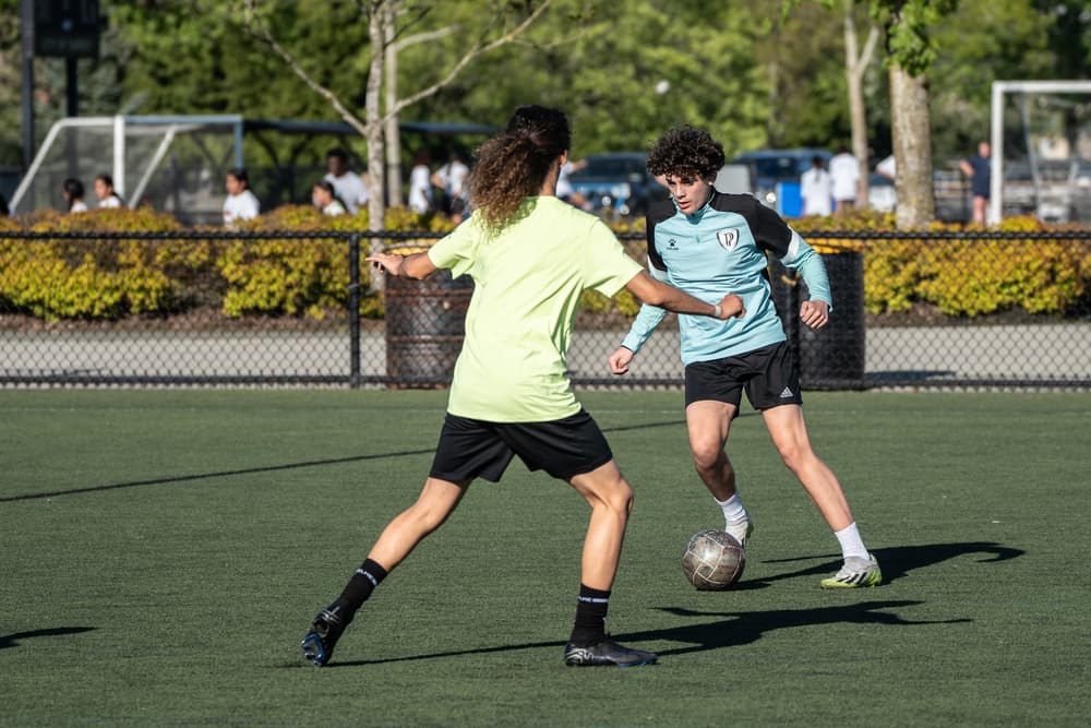Two Horizon Academy League players contesting the ball on a turf field